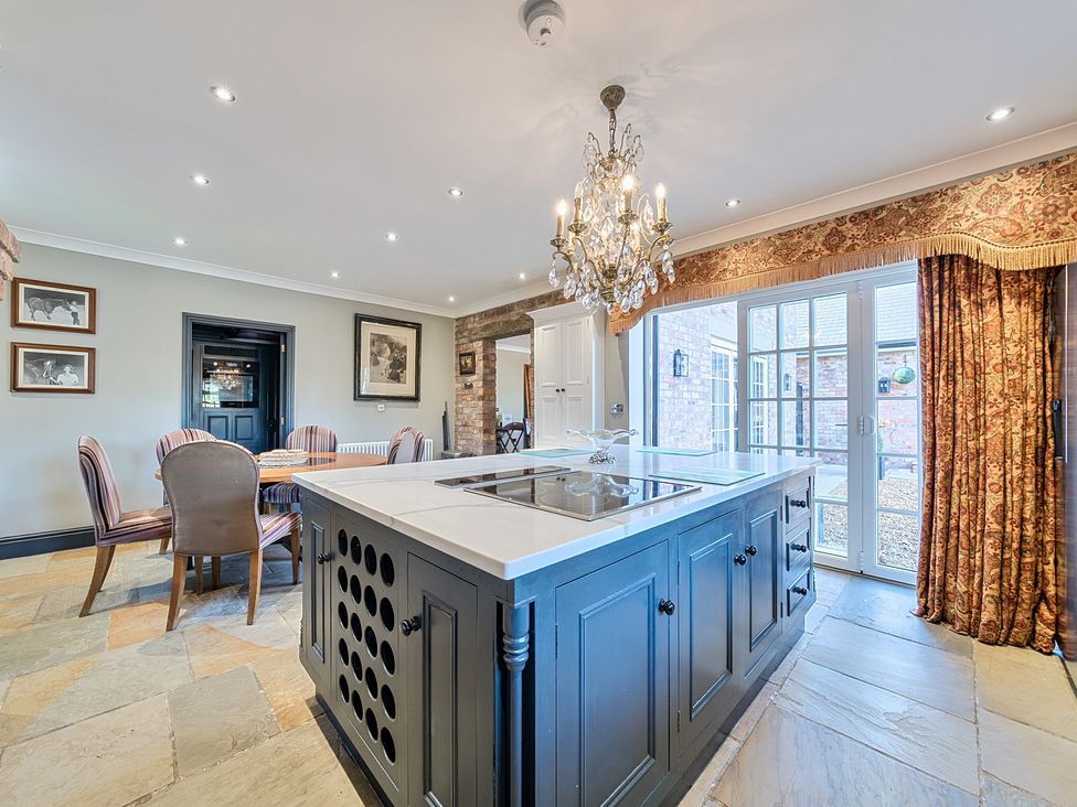 A kitchen with an island and dining area at Moor End Manor in Stalmine