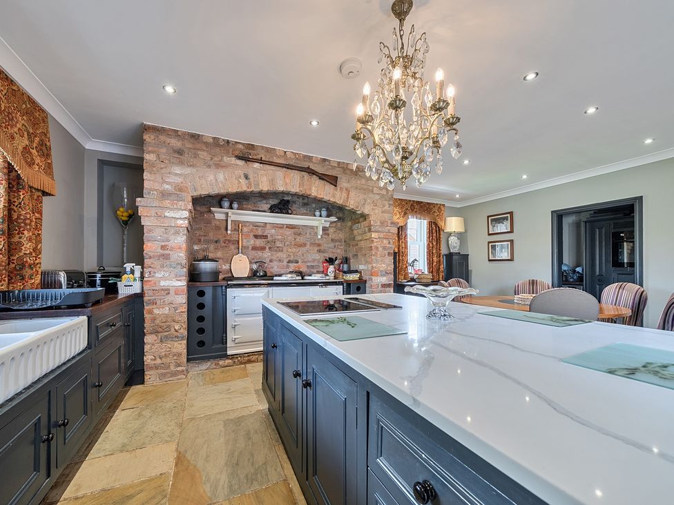 A kitchen with an island and brick wall at Moor End Manor in Stalmine