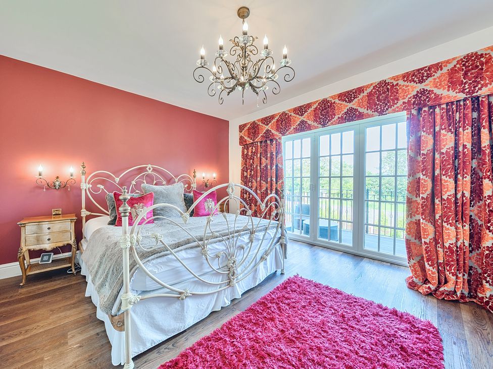 A bedroom with a bed and chandelier at Moor End Manor in Stalmine