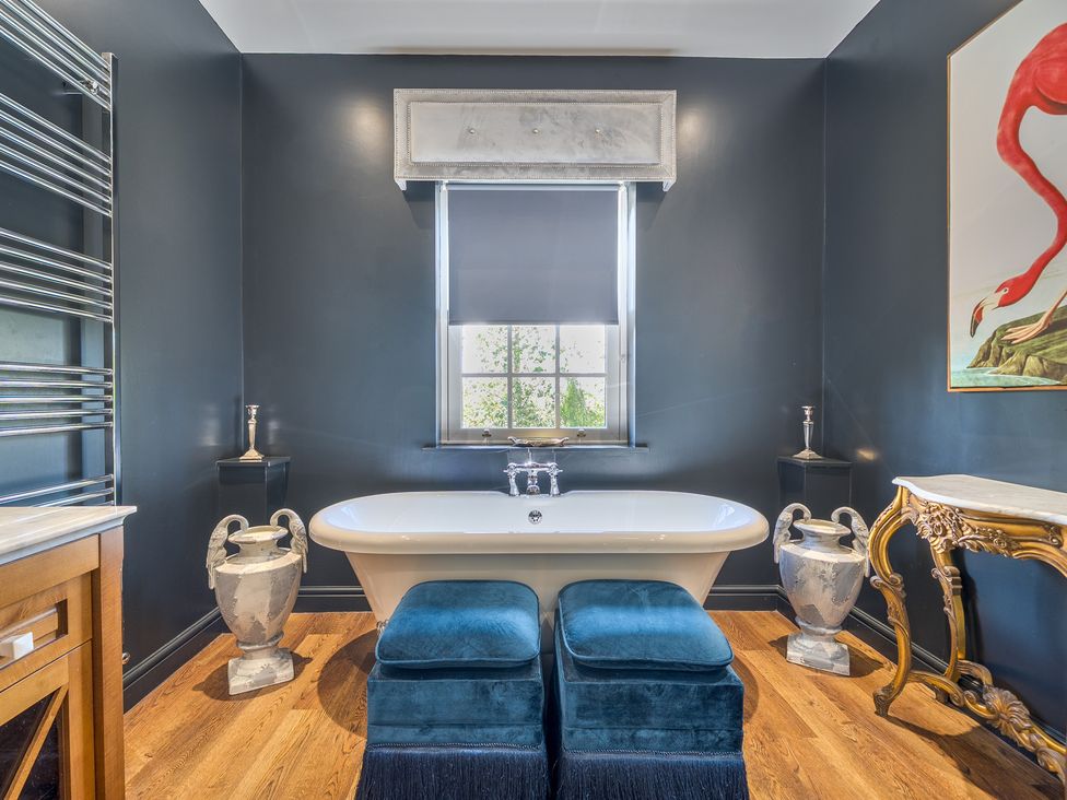 A bathroom with a bathtub and wooden furniture at Moor End Manor in Stalmine