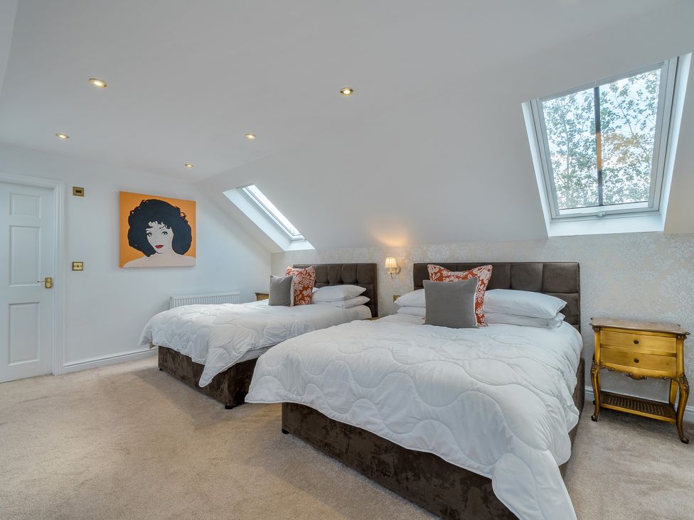 A bedroom with two beds and artwork on the wall at Moor End Manor Stalmine