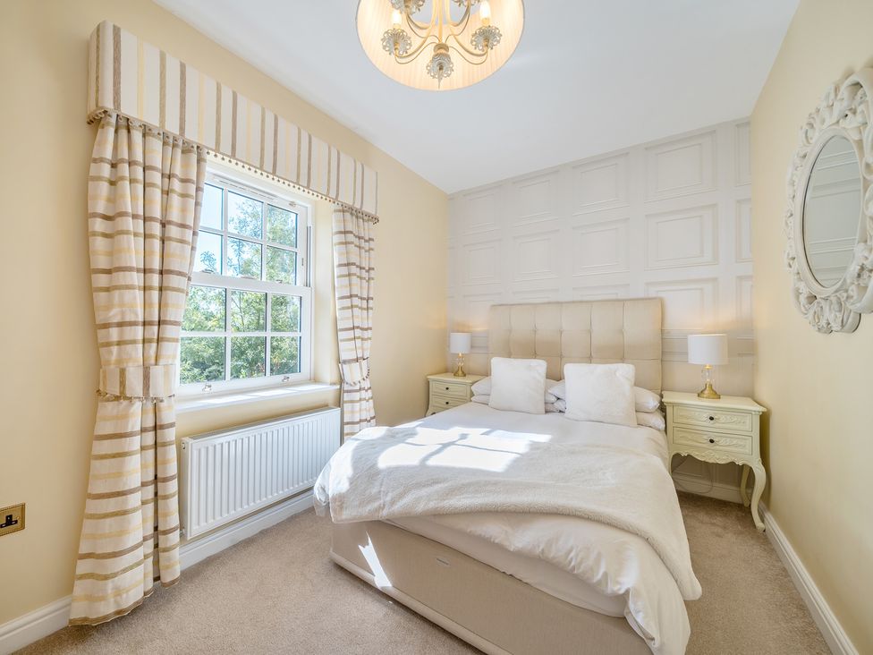A bedroom with a bed and windows at Moor End Manor in Stalmine