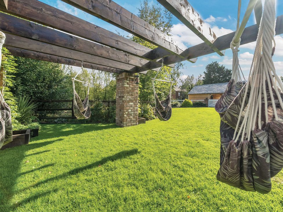 A garden with hammocks under a pergola at Moor End Manor Stalmine