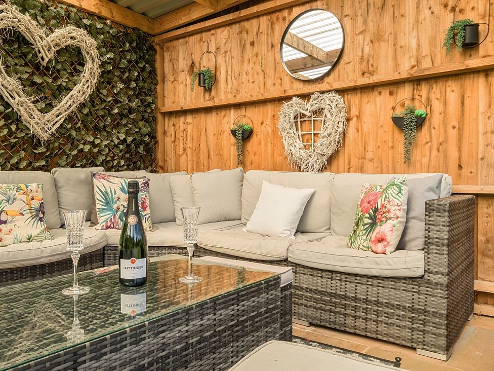 A garden seating area with a sofa and coffee table at Moor End Manor in Stalmine