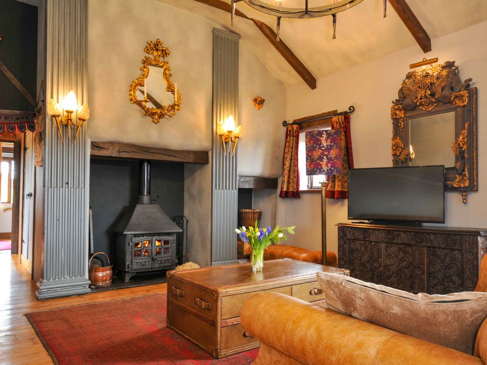 A living room with a fireplace and television at Lazy Hare at Jen's Orchard St Giles On The Heath