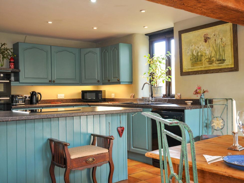 A kitchen with cabinets and appliances at Lazy Hare at Jen's Orchard in St Giles On The Heath