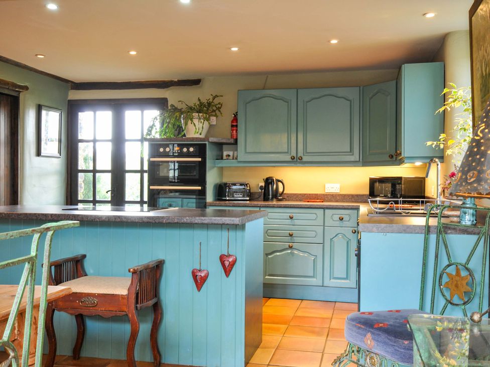 A kitchen with cabinets and appliances at Lazy Hare at Jen's Orchard in St Giles On The Heath