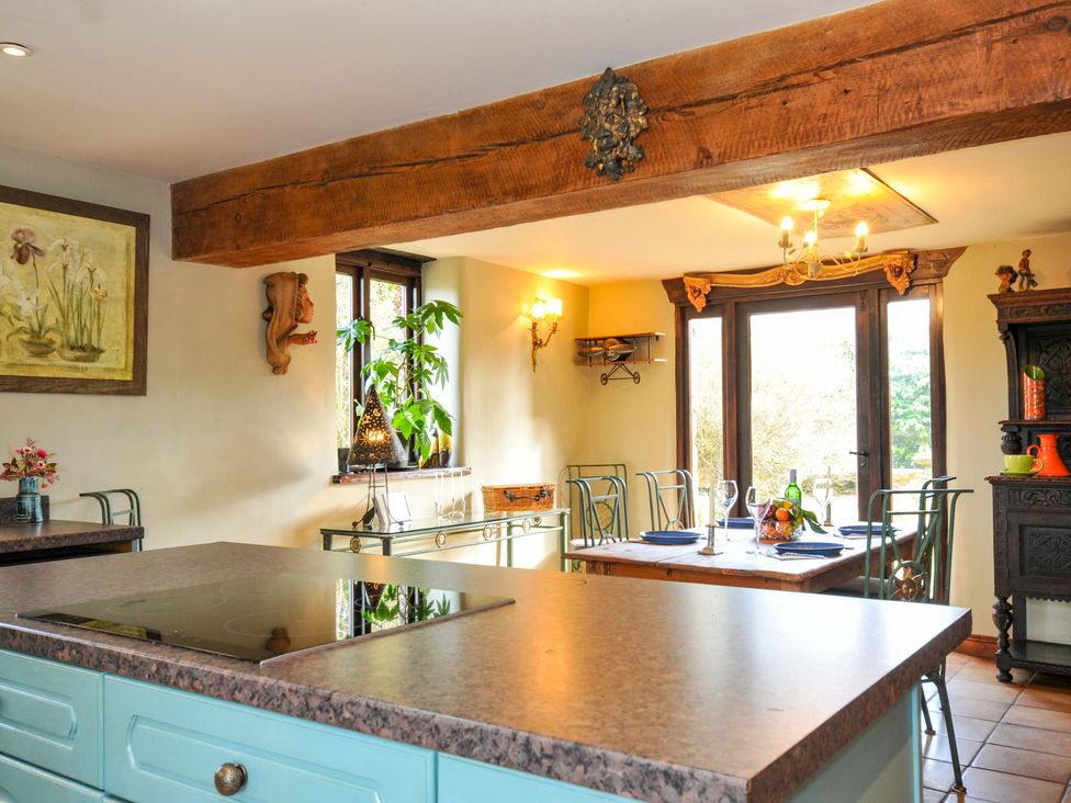 A kitchen with a stove and dining area at Lazy Hare at Jen's Orchard St Giles On The Heath