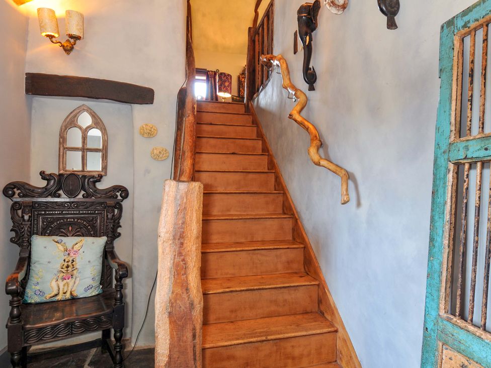 An entrance area with stairs and a chair at Lazy Hare at Jen's Orchard St Giles On The Heath