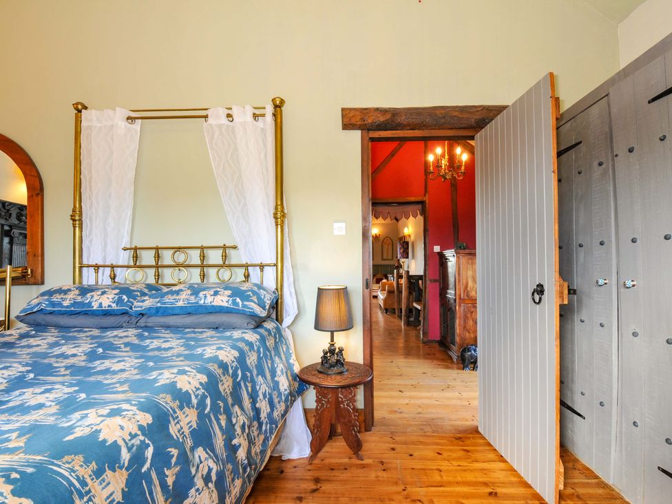 A bedroom with a bed and a wardrobe at Lazy Hare at Jen's Orchard St Giles On The Heath