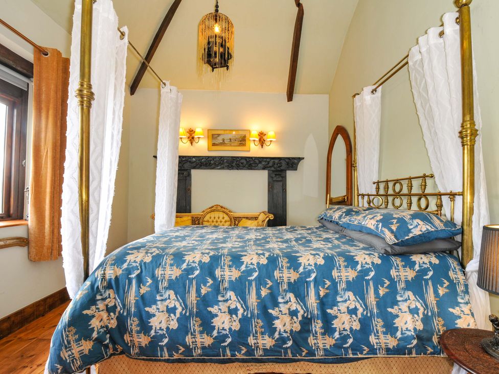 A bedroom with a bed and fireplace at Lazy Hare at Jen's Orchard St Giles On The Heath