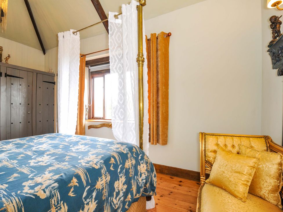 A bedroom with a bed and wardrobe at Lazy Hare at Jen's Orchard, St Giles On The Heath