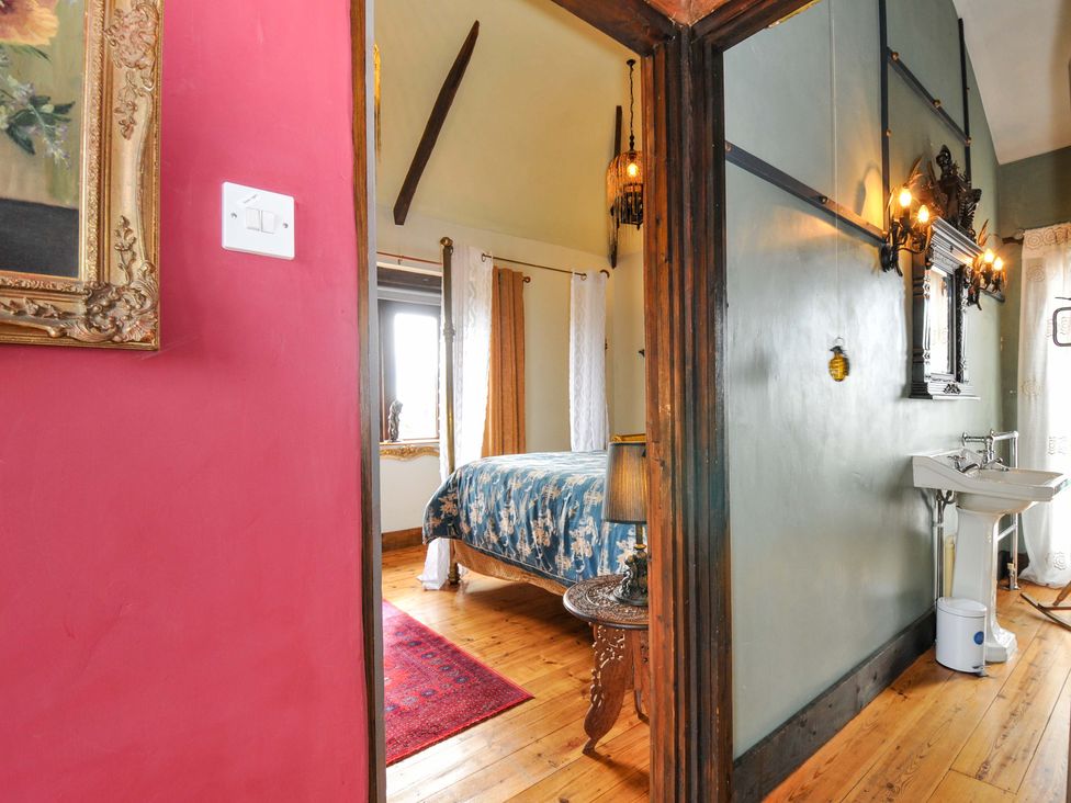 A bedroom with a bed and decorative lamp at Lazy Hare at Jen's Orchard in St Giles On The Heath