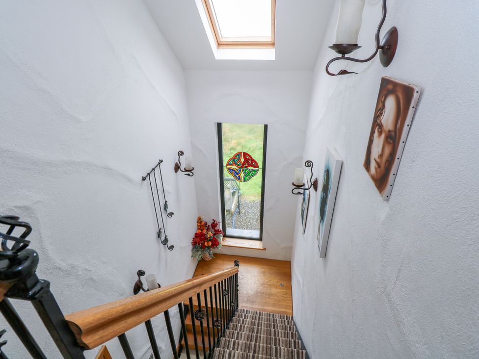 A staircase leading to a window with flower arrangement at Ocean Sail House Termon near Dungloe, County Donegal
