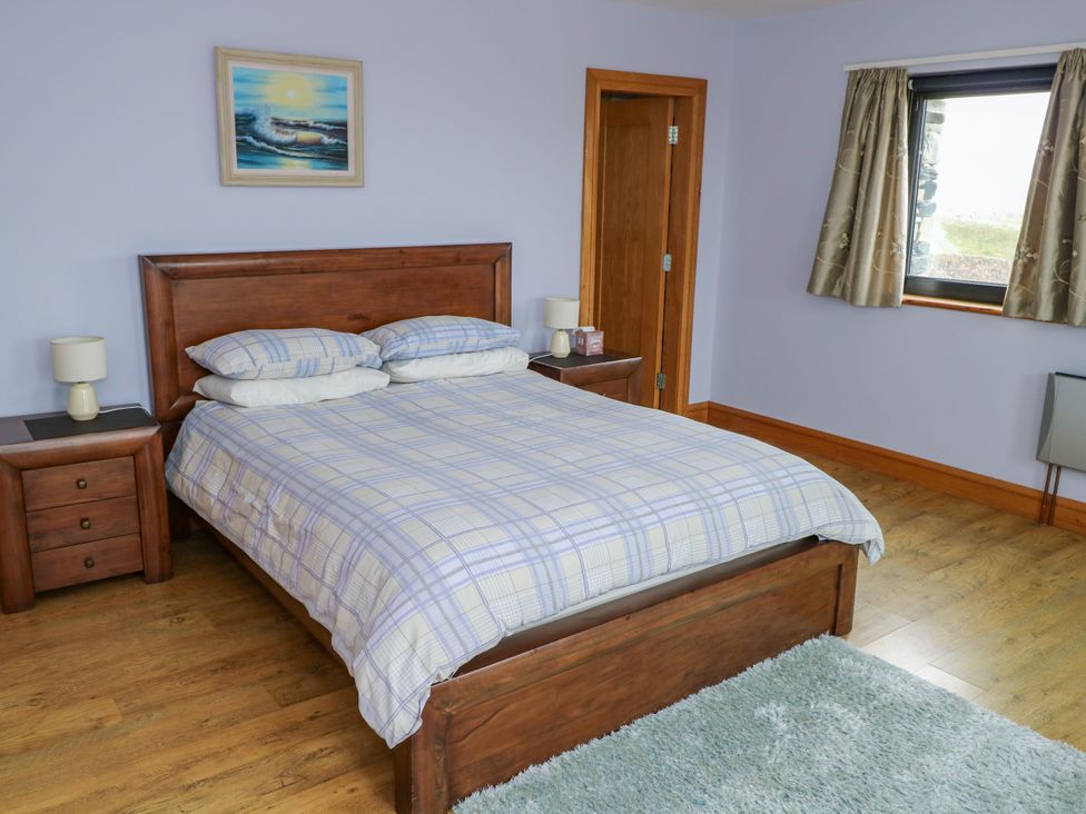 A bedroom with a bed and bedside tables at Ocean Sail House in Termon near Dungloe, County Donegal