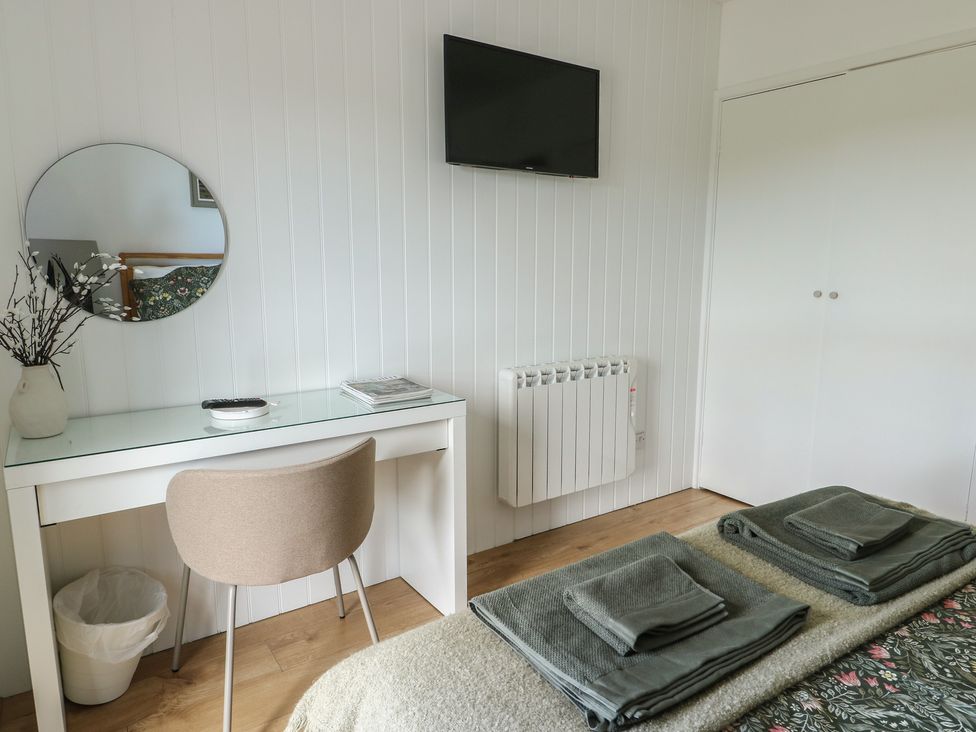 A bedroom with a bed and desk at Bwthyn in Moelfre