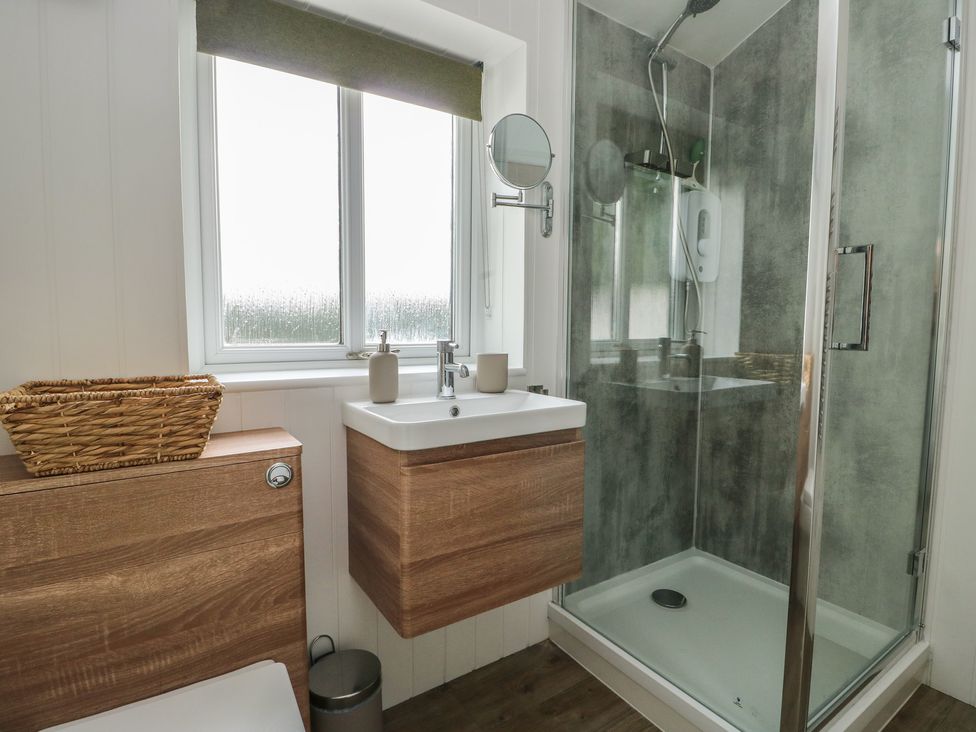 A bathroom with a shower and a wash basin at Bwthyn Moelfre