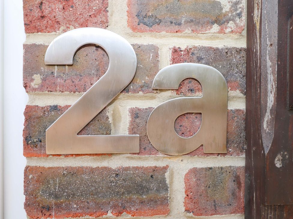 House number 2a on a brick wall at 2A The Mews Langstone
