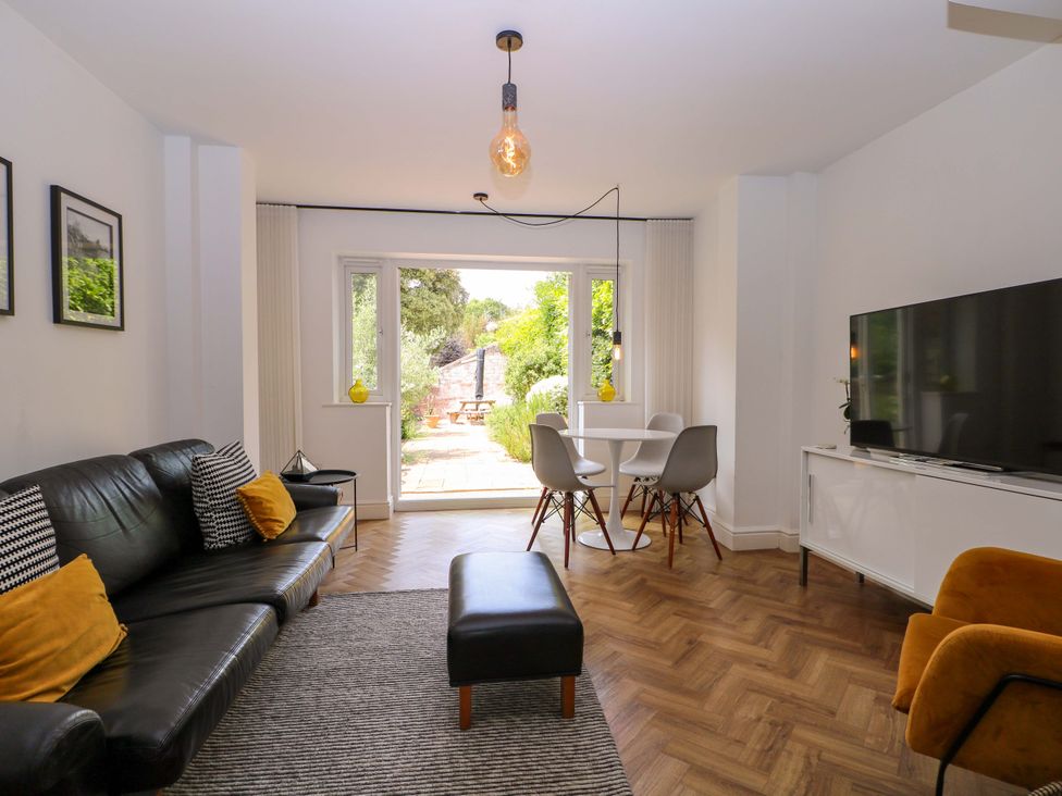 A living room with a sofa and a dining table at 2A The Mews Langstone