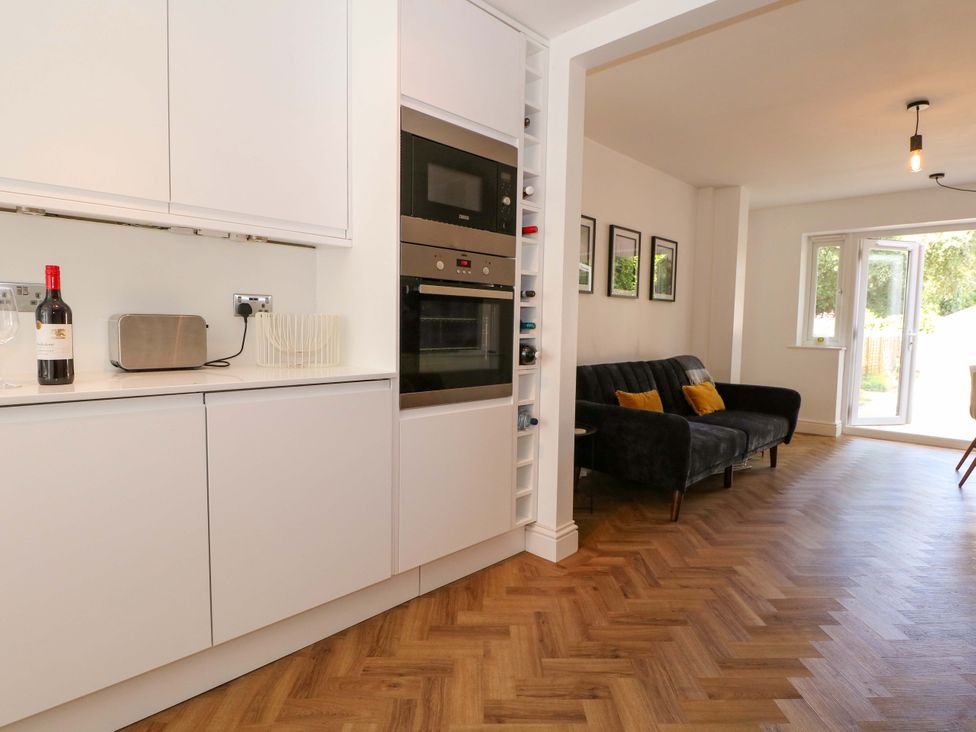 A kitchen with appliances and a sofa at 2A The Mews Langstone