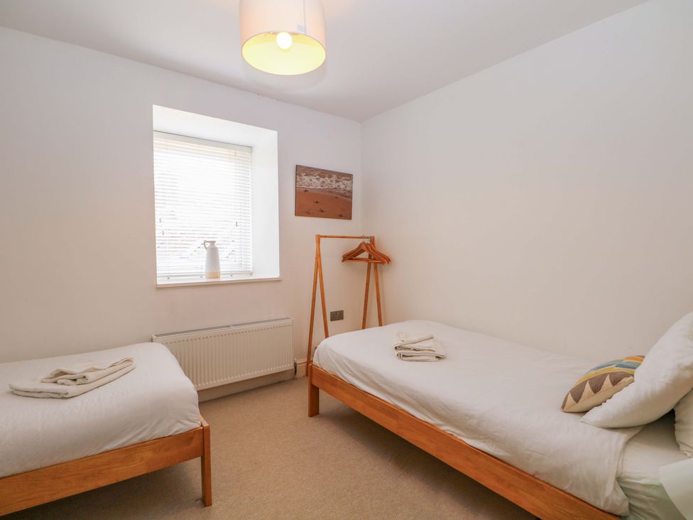A bedroom with two single beds and a window at 2A The Mews in Langstone