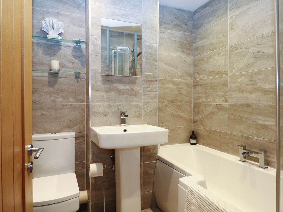 A bathroom with a sink, toilet and bathtub at 2A The Mews in Langstone