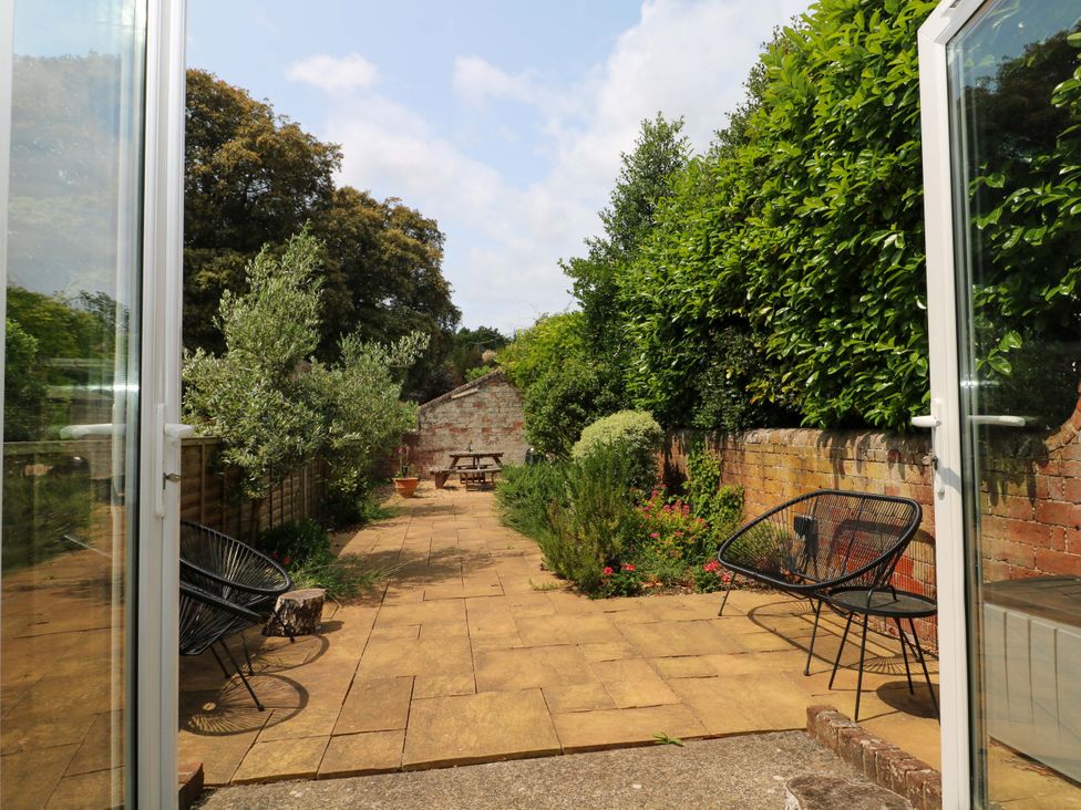 A garden with chairs and a table surrounded by plants at 2A The Mews, Langstone