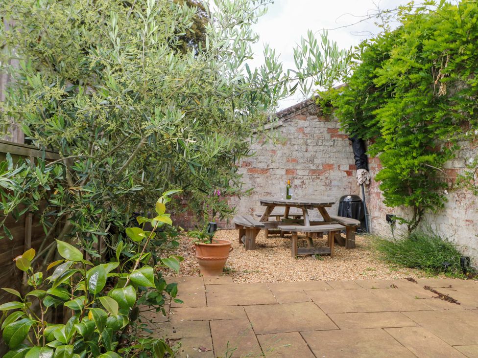 A garden with a table and chairs at 2A The Mews, Langstone