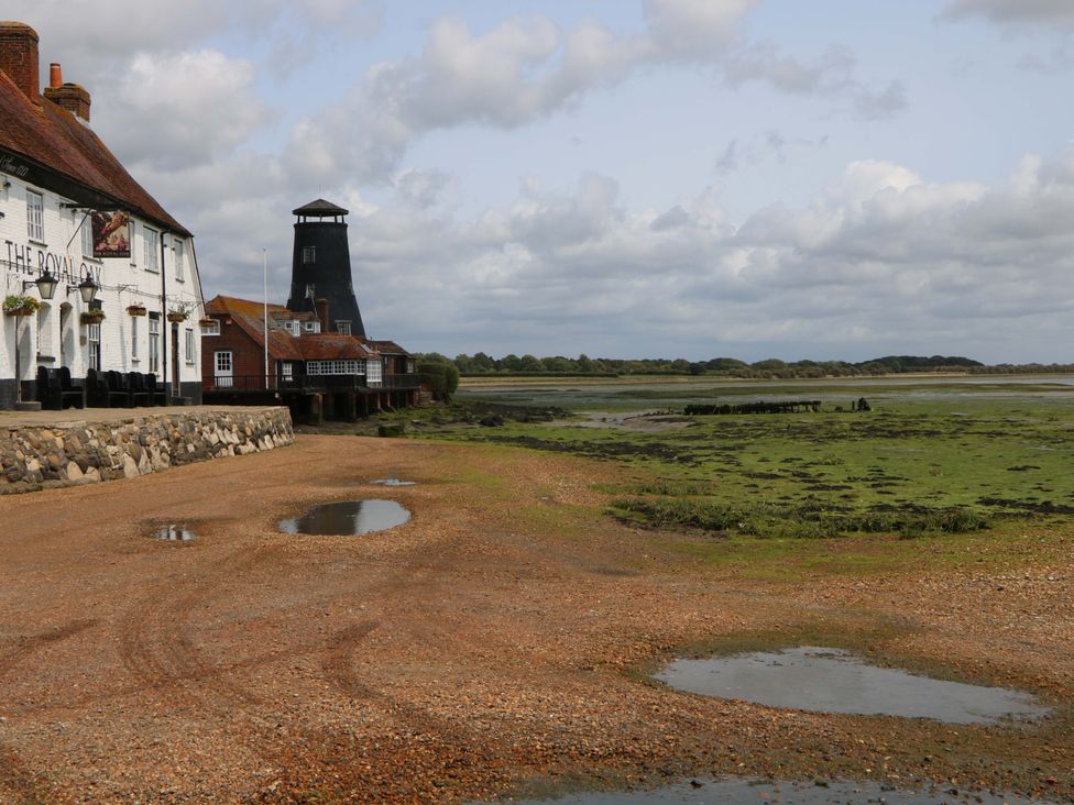 A coastal view with a pub and a tower at 2A The Mews Langstone