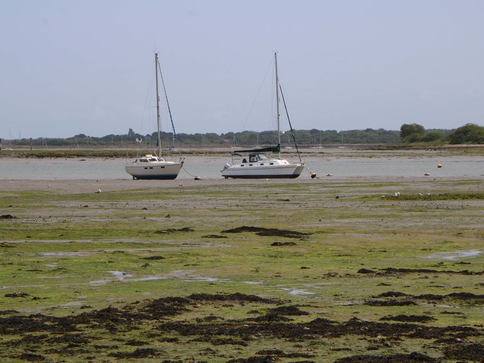 Two sailboats anchored on a mudflat with seaweed at 2A The Mews in Langstone