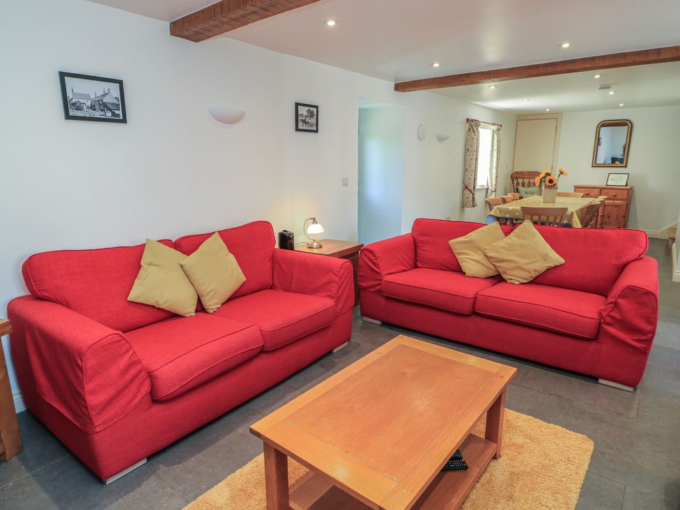 A living room with red sofas and a coffee table at Dale Barton in Wells