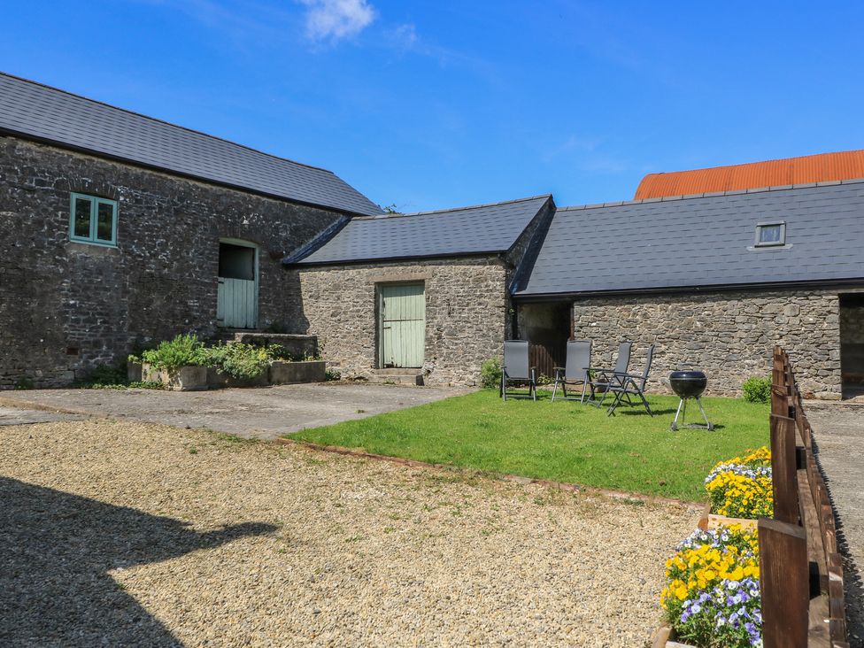 An outdoor area with stone buildings and garden furniture at Dale Barton in Wells