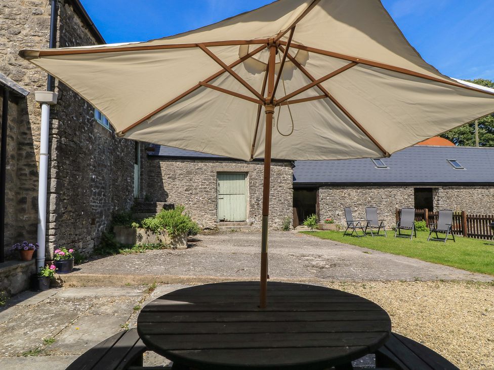 A garden with an umbrella and table at Dale Barton in Wells