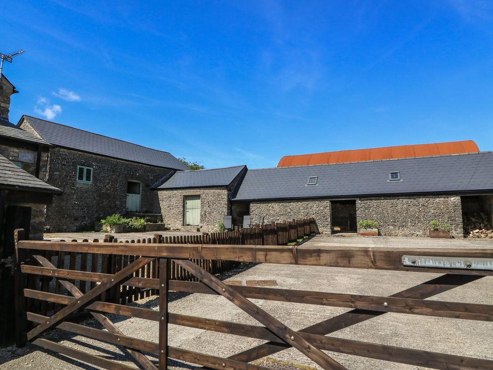 An outdoor area with stone buildings and a wooden gate at Dale Barton in Wells