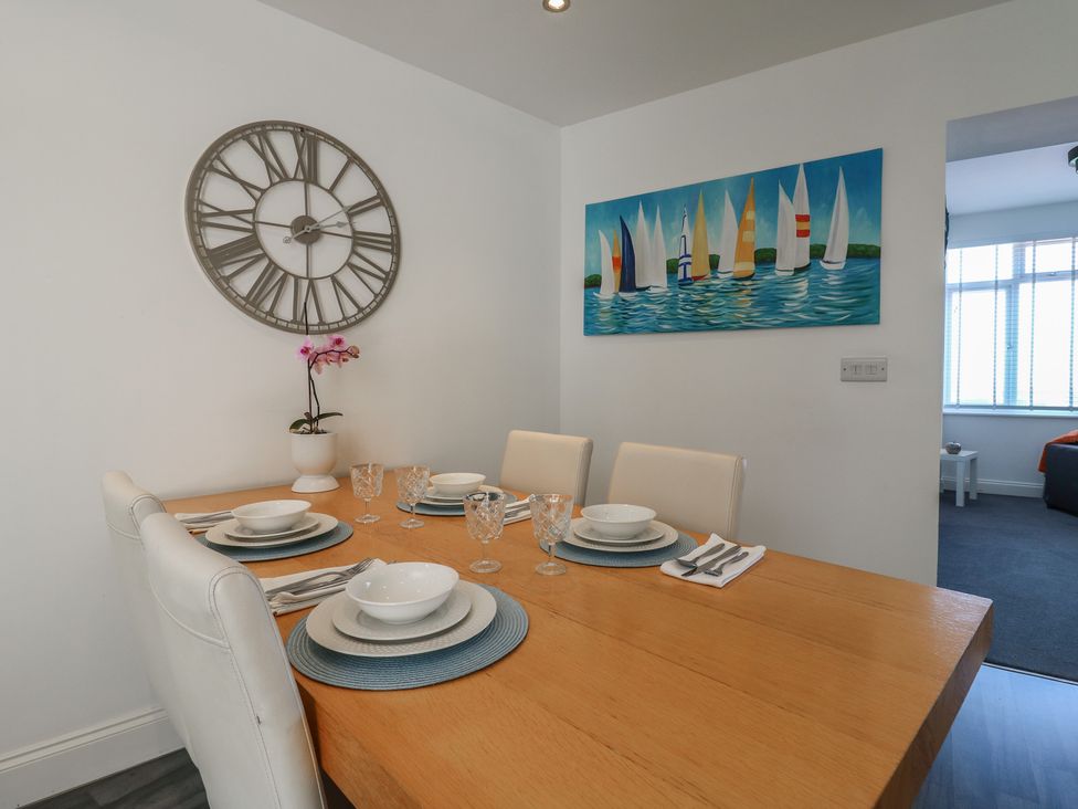 A dining room with a clock and a painting at 38 The Parade Walton-On-The-Naze