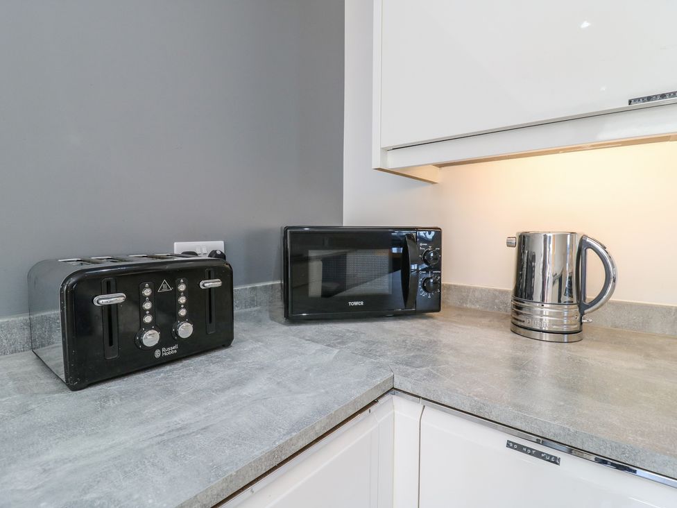 A kitchen countertop with a toaster, microwave, and kettle at 38 The Parade Walton-On-The-Naze