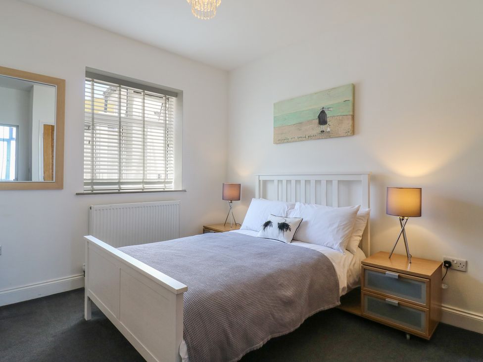 A bedroom with a bed, bedside tables, and window at 38 The Parade Walton-On-The-Naze