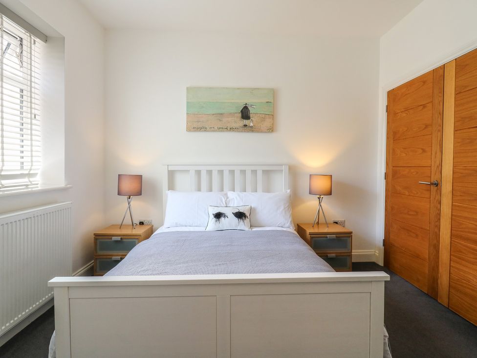 A bedroom with a bed and nightstand at 38 The Parade Walton-On-The-Naze