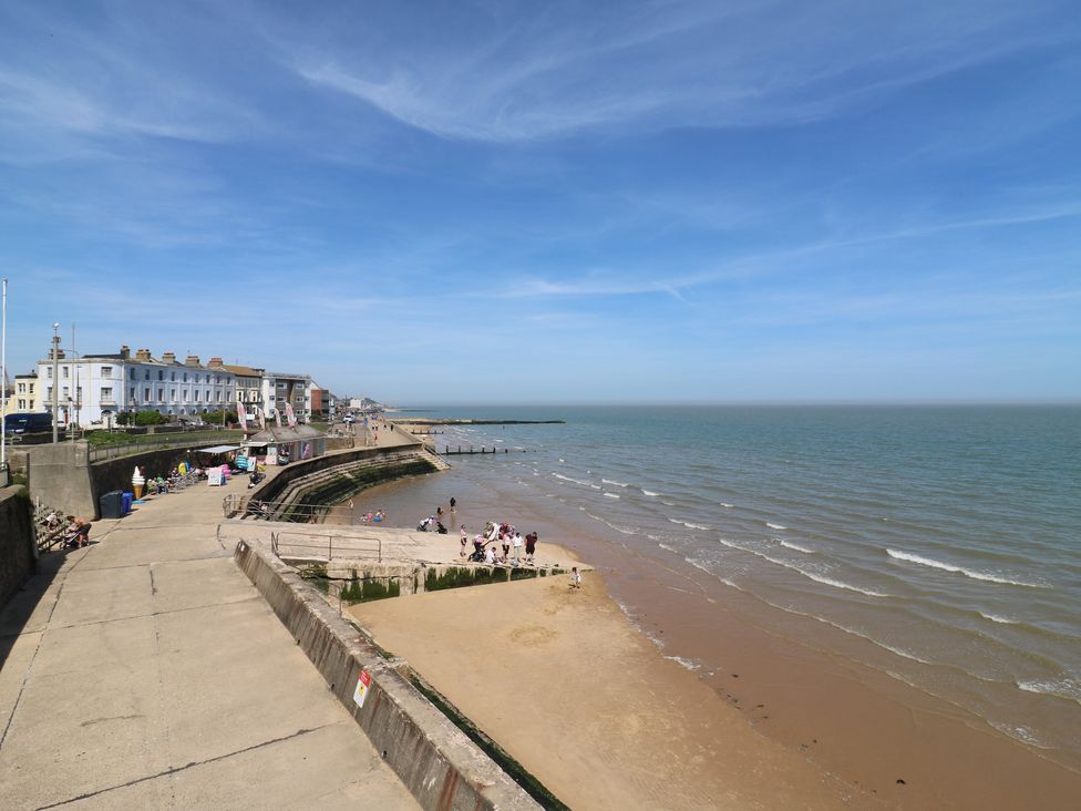 A beach with people and buildings along the promenade at 38 The Parade Walton-On-The-Naze