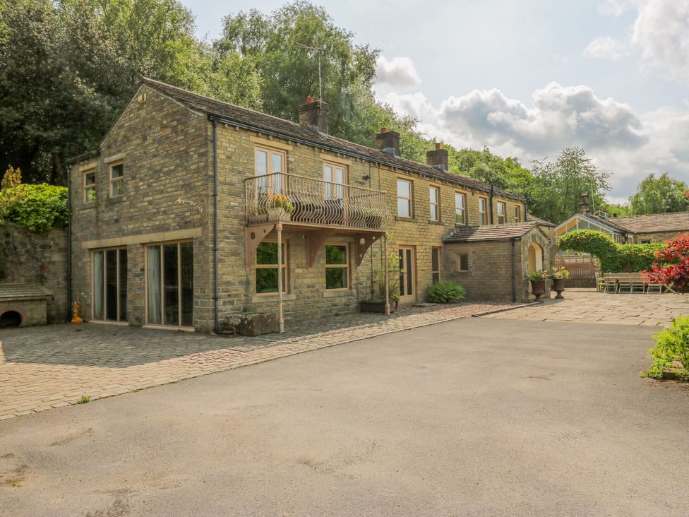 A house with a balcony and gardens at Woodbottom Farm in Meltham