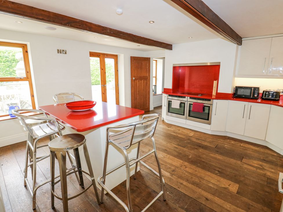 A kitchen with a red island and appliances at Woodbottom Farm in Meltham