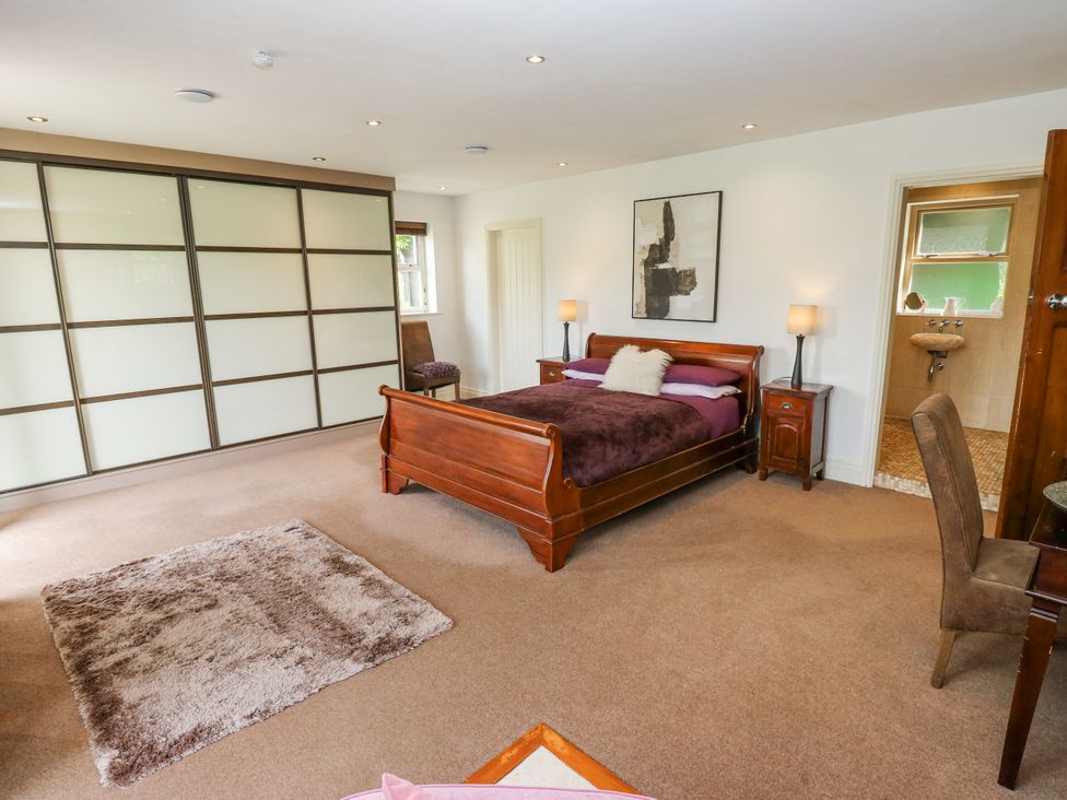 A bedroom with a bed and nightstands at Woodbottom Farm in Meltham