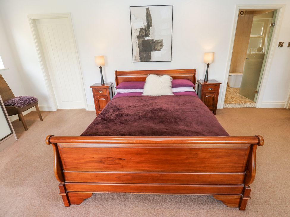 A bedroom with a bed and nightstands at Woodbottom Farm in Meltham