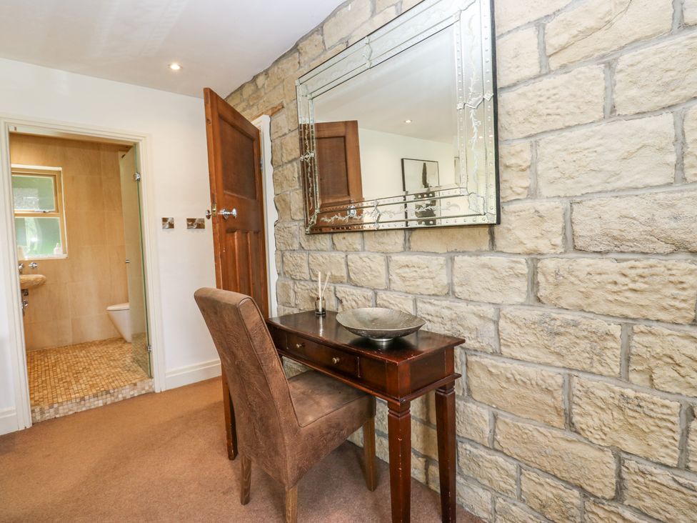 A hallway with a table and mirror at Woodbottom Farm in Meltham