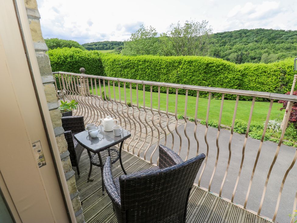 A balcony with a table and chairs at Woodbottom Farm in Meltham