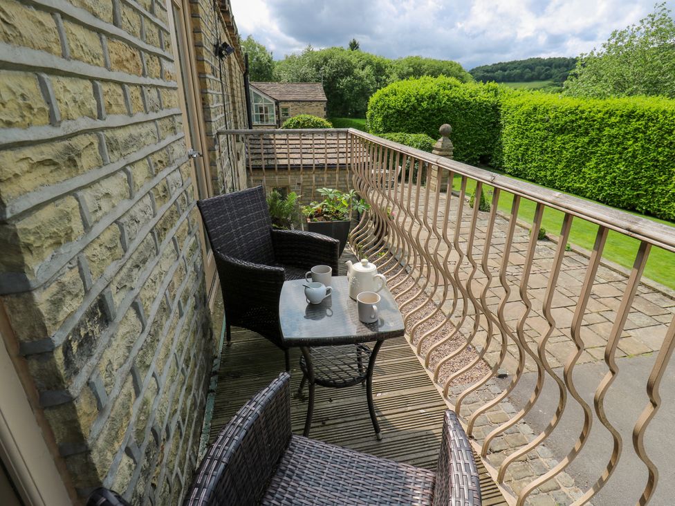 A balcony with a table and chairs at Woodbottom Farm Meltham