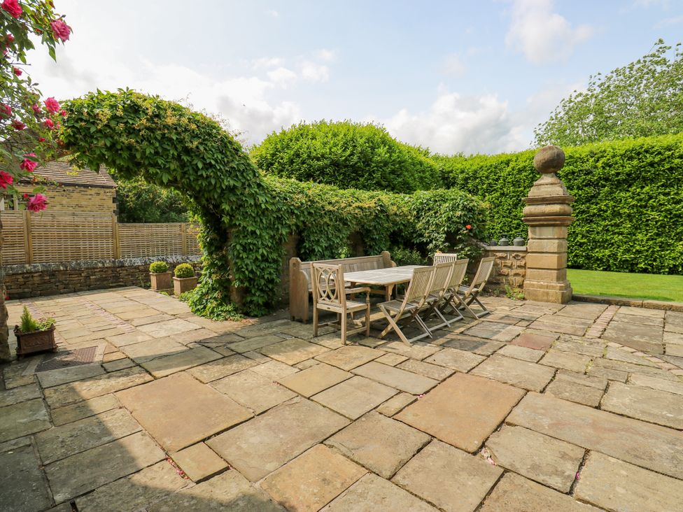 A garden with a dining table and chairs at Woodbottom Farm Meltham