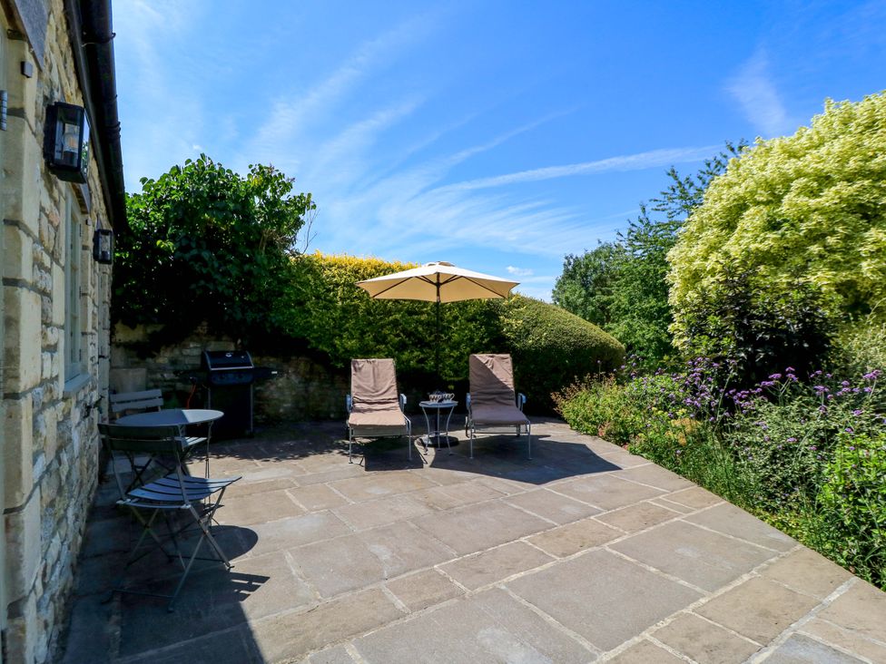 An outdoor area with chairs and a table at Pheasant Cottage in Priston Village, BATH