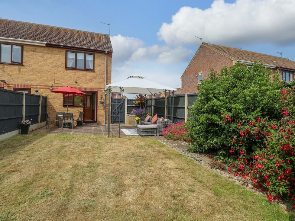 A garden with a table and chairs under a canopy at Breydon Cottage in Bradwell near Gorleston-On-Sea