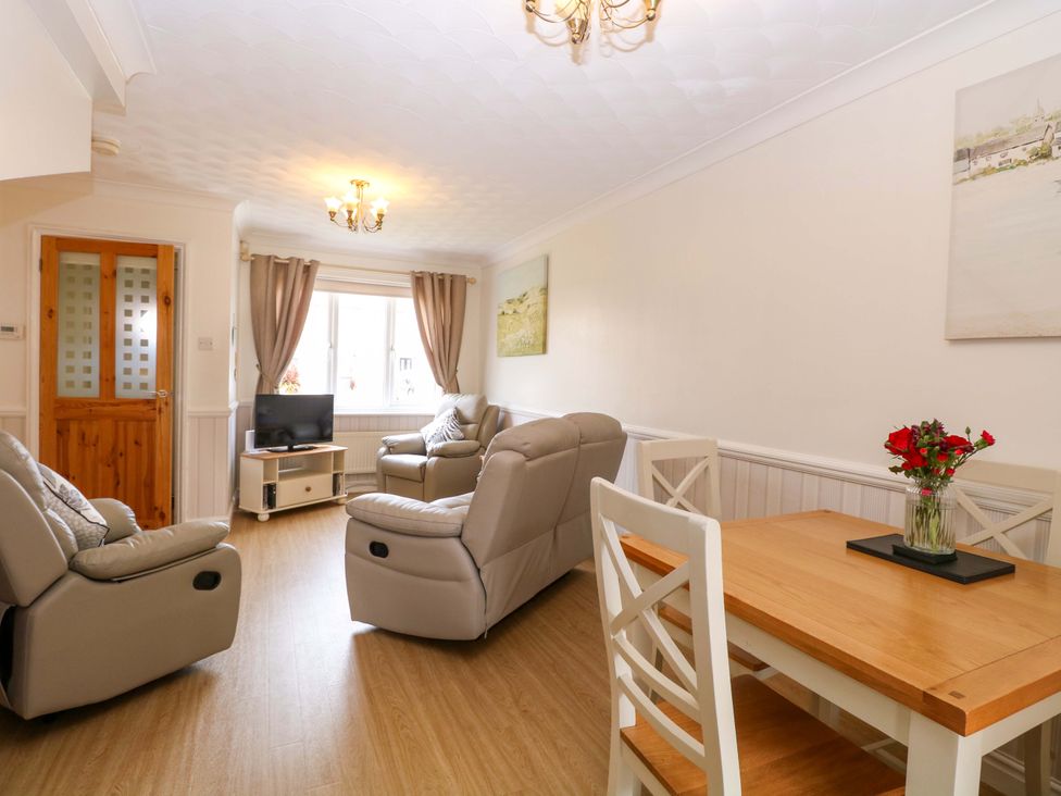 A living room with a table and chairs at Breydon Cottage in Bradwell near Gorleston-On-Sea